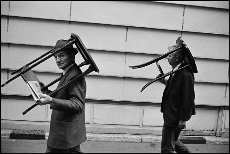 Richard Kalvar/ Magnum Photos FRANCE. Paris. 1971. Men walking with tables on their heads.